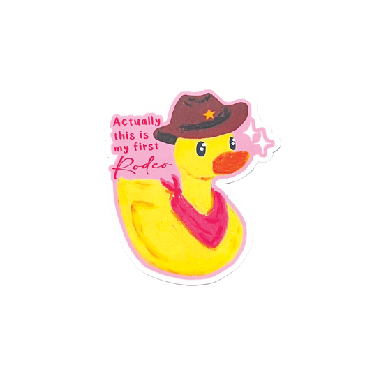 Yellow rubber duck wearing a cowboy hat and bandana with text 'actually this is my first rodeo' on a white background