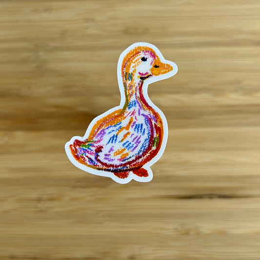 Colorful duck-shaped sticker on a wooden surface