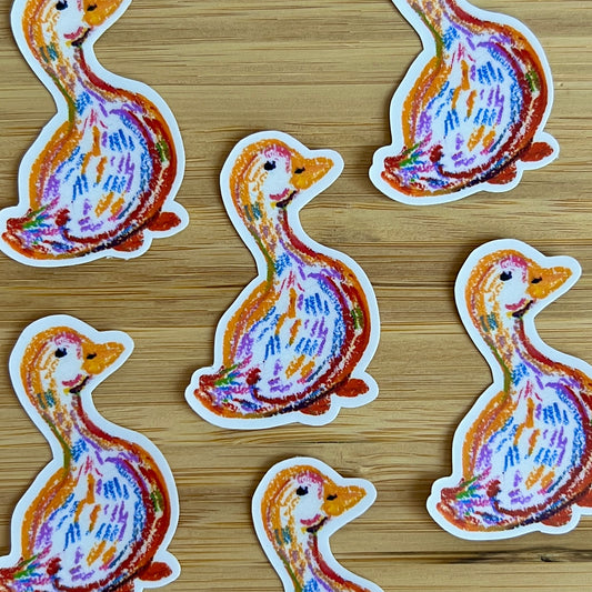 Colorful duck-shaped stickers on a wooden surface