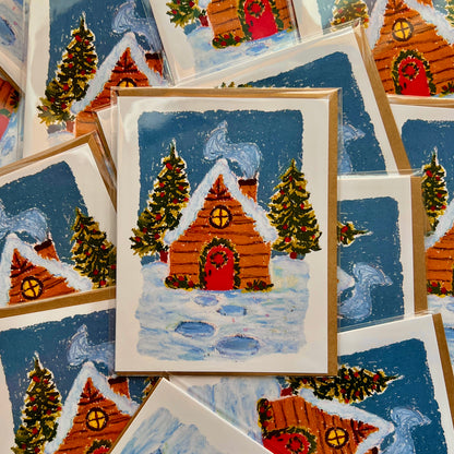 Collection of Christmas-themed cards with snowy cabins and trees.