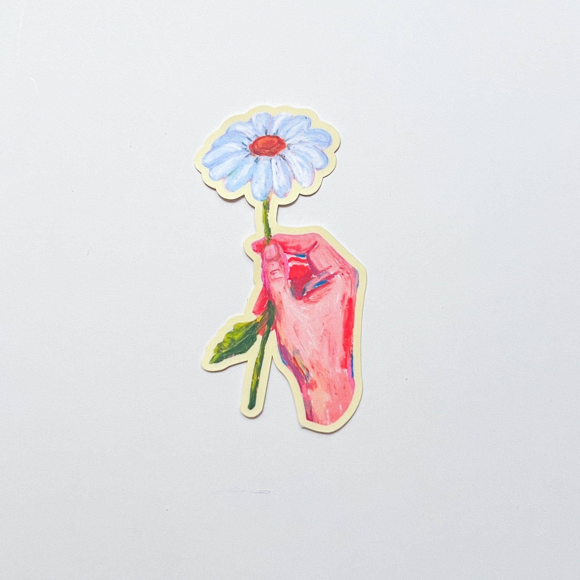 Sticker of a hand holding a flower on a light gray background