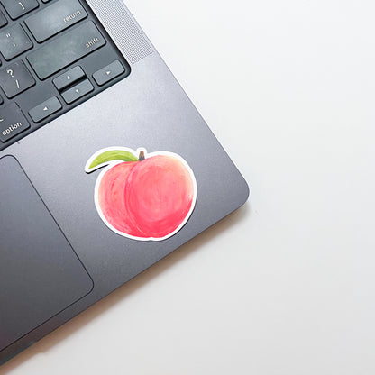 Laptop with a peach-shaped sticker on the palm rest area