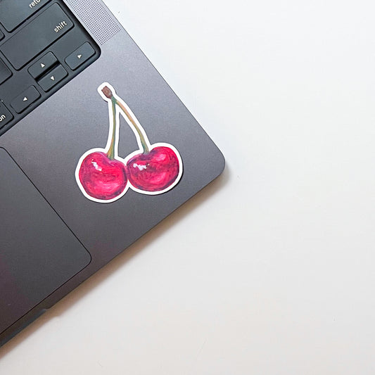 Laptop with a cherry sticker on a white background