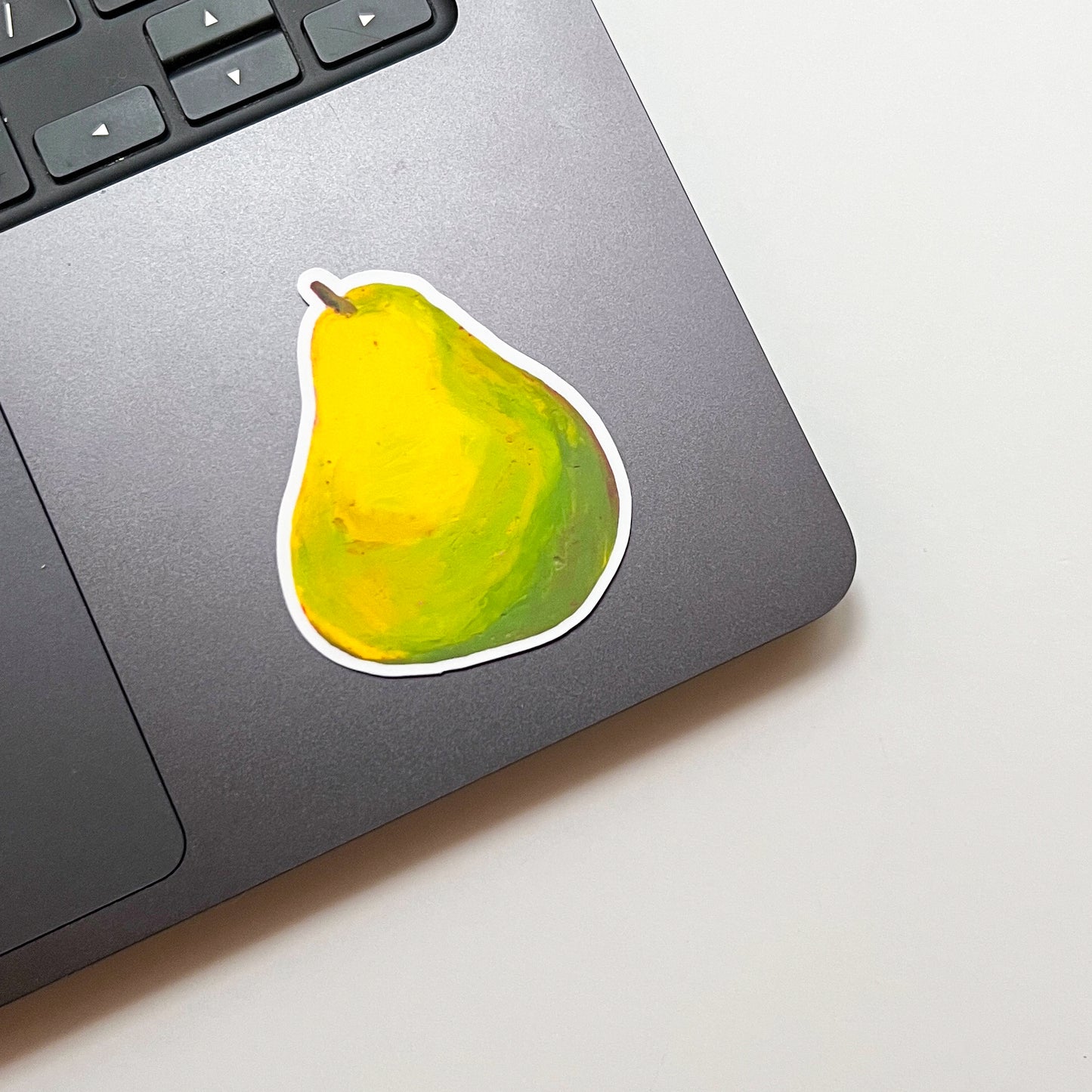 Laptop with a pear-shaped sticker on a light surface
