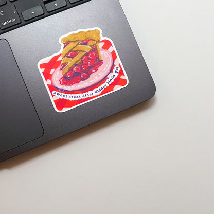 Laptop with a pie-themed sticker on a light surface