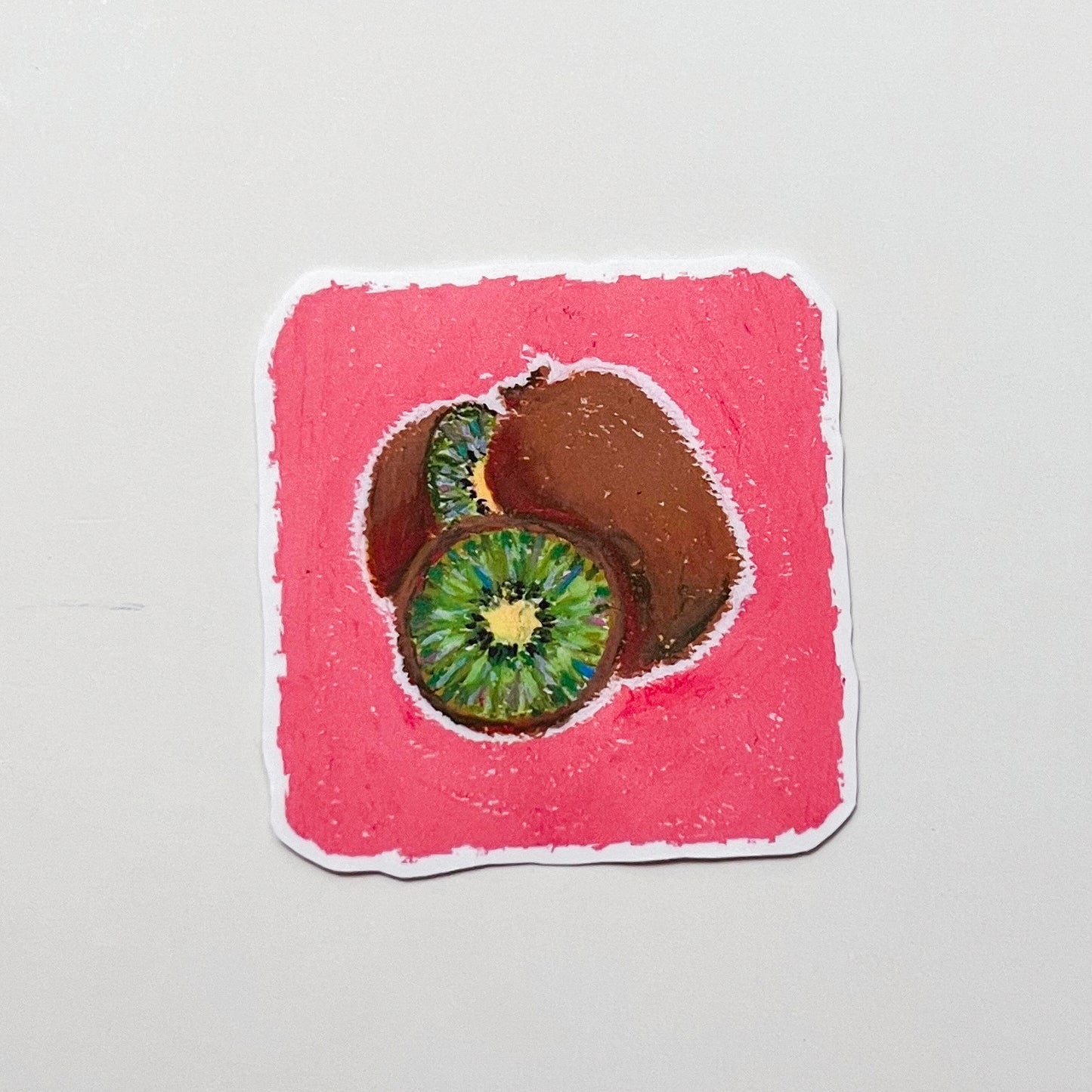 Sticker of a sliced kiwi fruit on a pink background