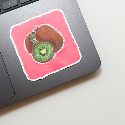 Laptop with a colorful sticker of a kiwi fruit on a pink square