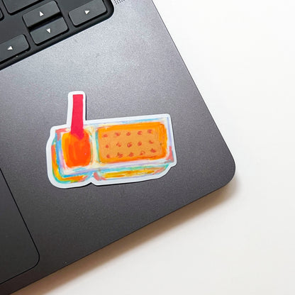 Colorful sticker of cheese dip and crackers on a laptop