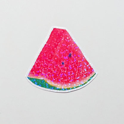 Watermelon slice with pink glitter on a light gray background