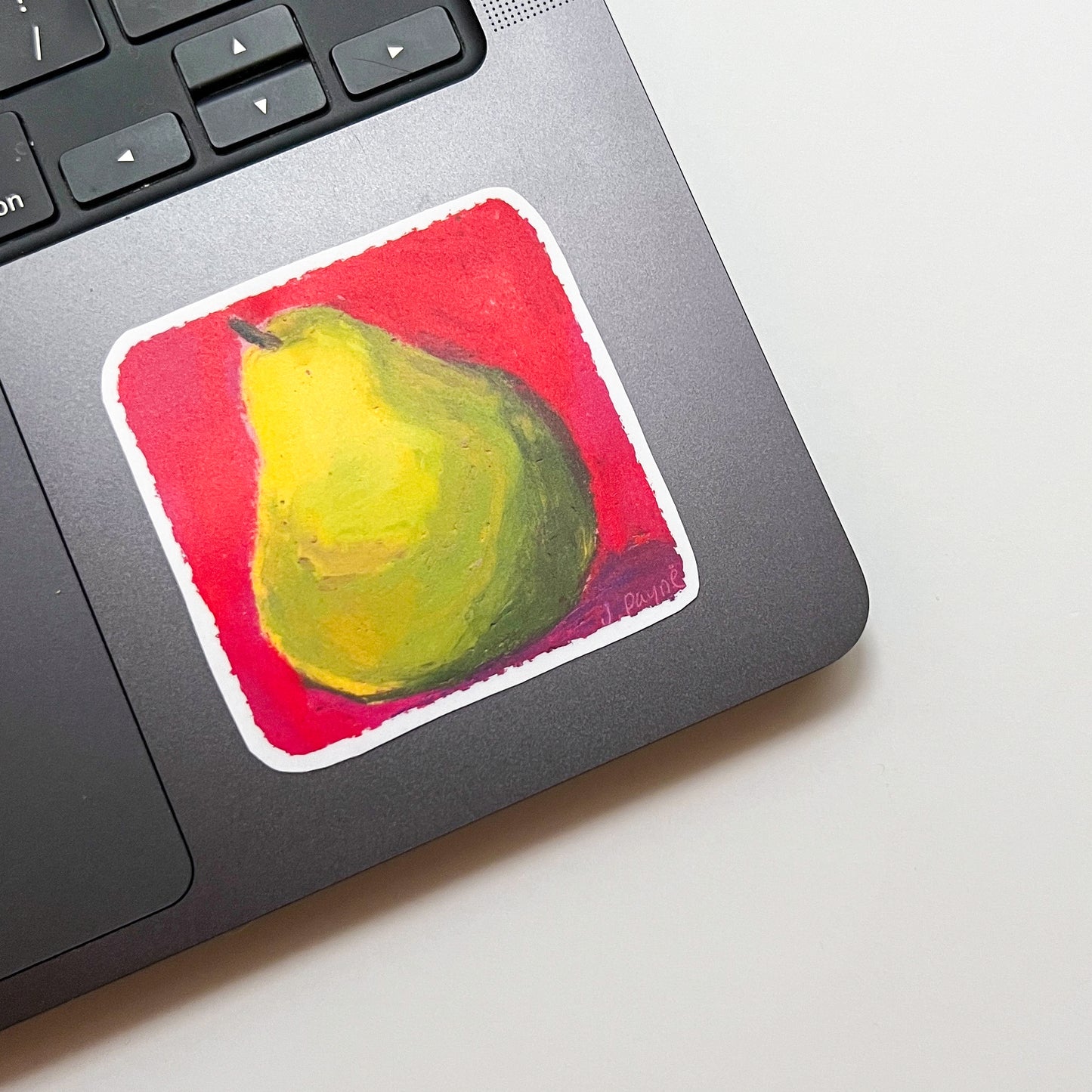 Laptop with a painting of a pear on the palm rest area