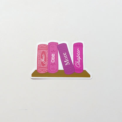 Sticker design of four pink books with text 'just one more chapter' on a white background