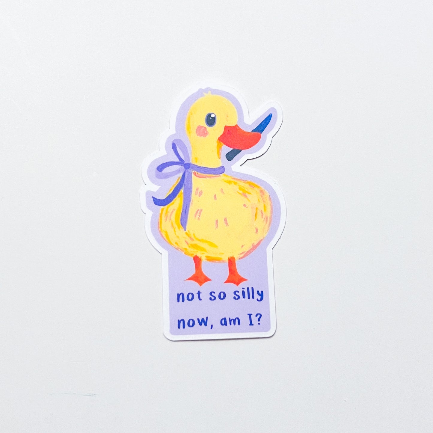 Sticker of a yellow duck with a purple bow and text on a light gray background