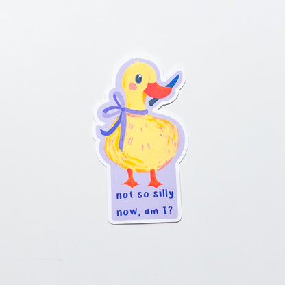 Sticker of a yellow duck with a purple bow and text on a light gray background