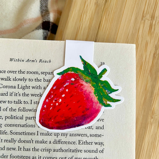 Strawberry magentic bookmark with a wooden surface in the background
