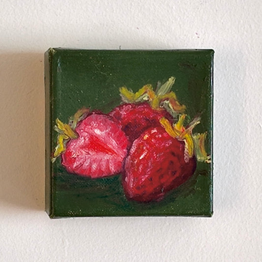 Small painting of strawberries on a green background