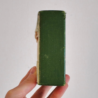 Hand holding a green canvas side profile against a white background