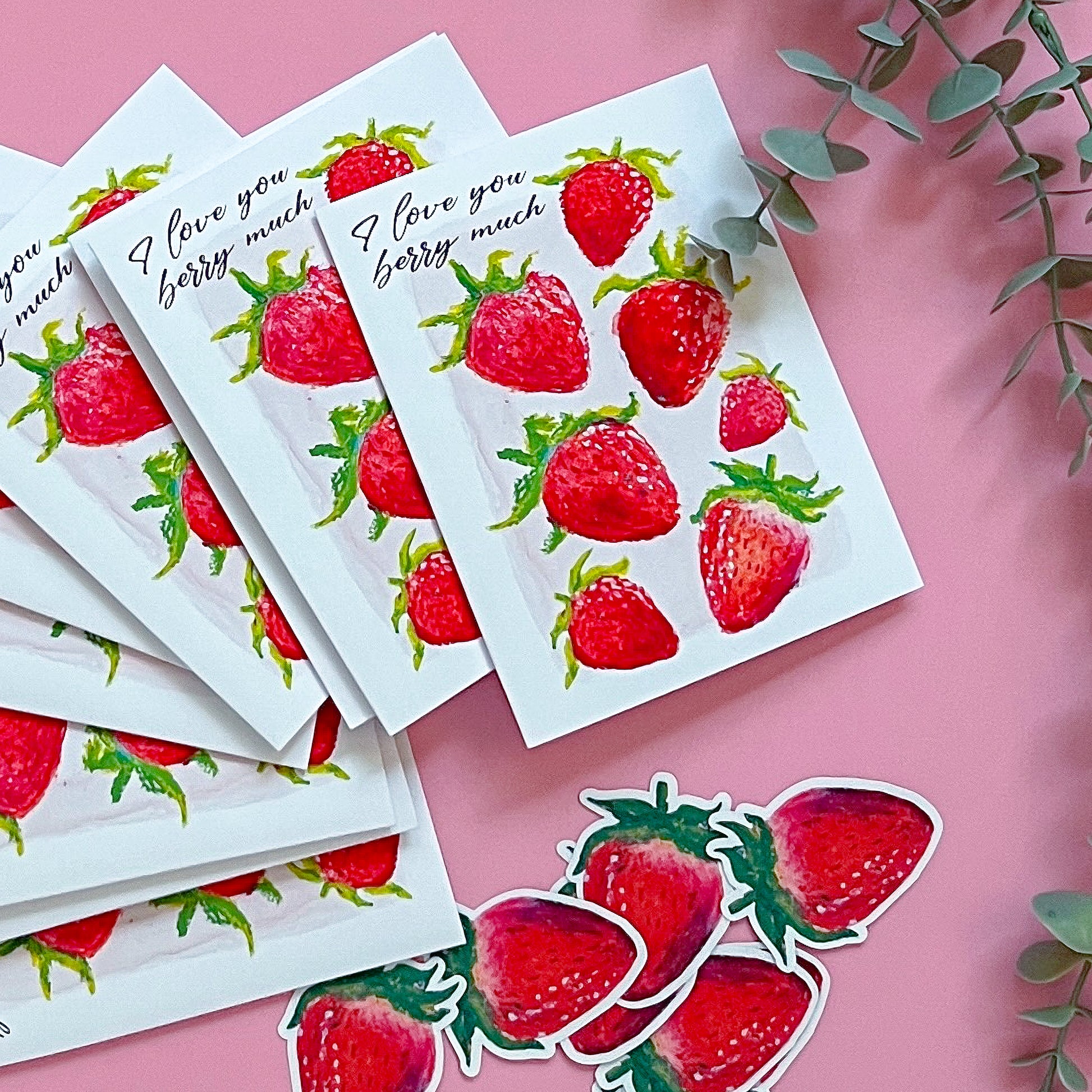 Strawberry stickers and cards with 'I love you berry much' text on a pink background.
