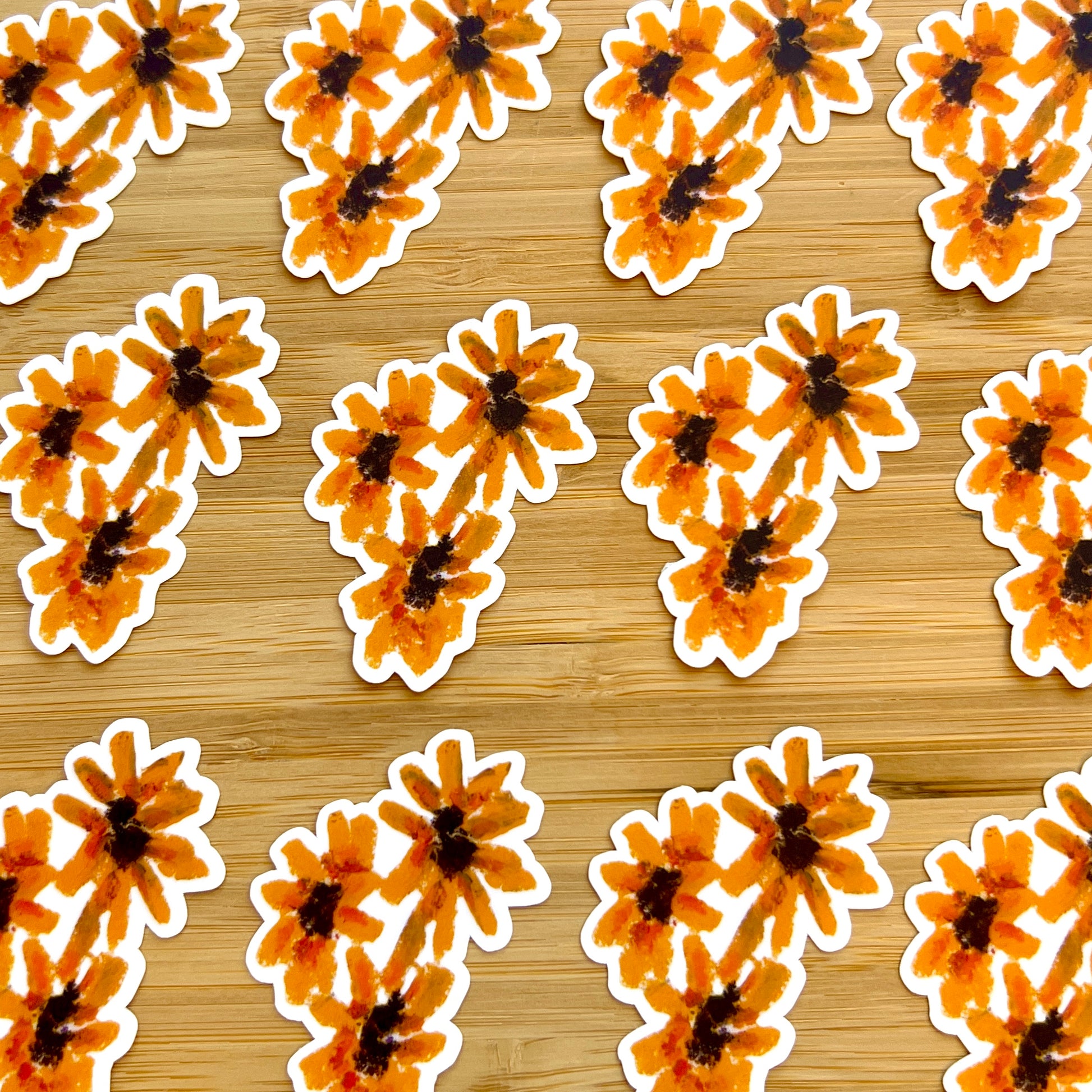Pattern of orange flowers with black centers on a wooden background
