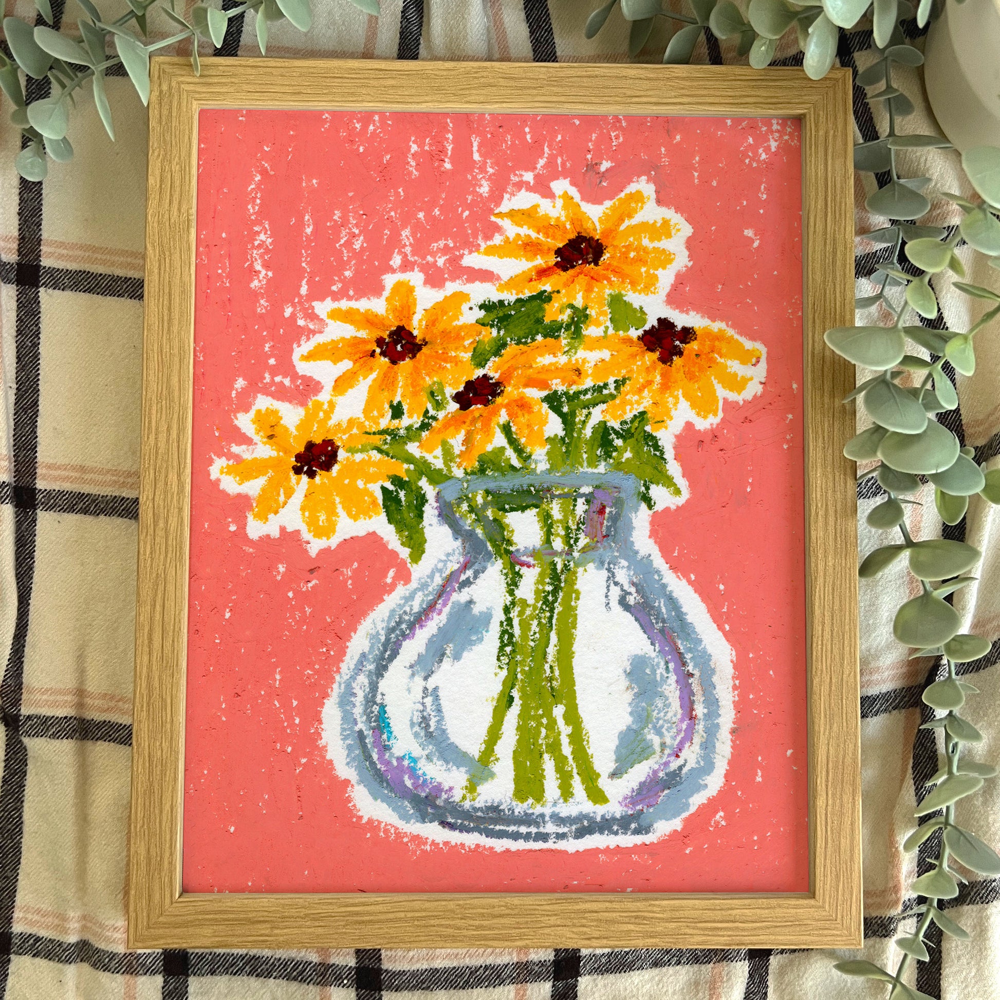 Framed artwork of a vase with yellow flowers on a pink background