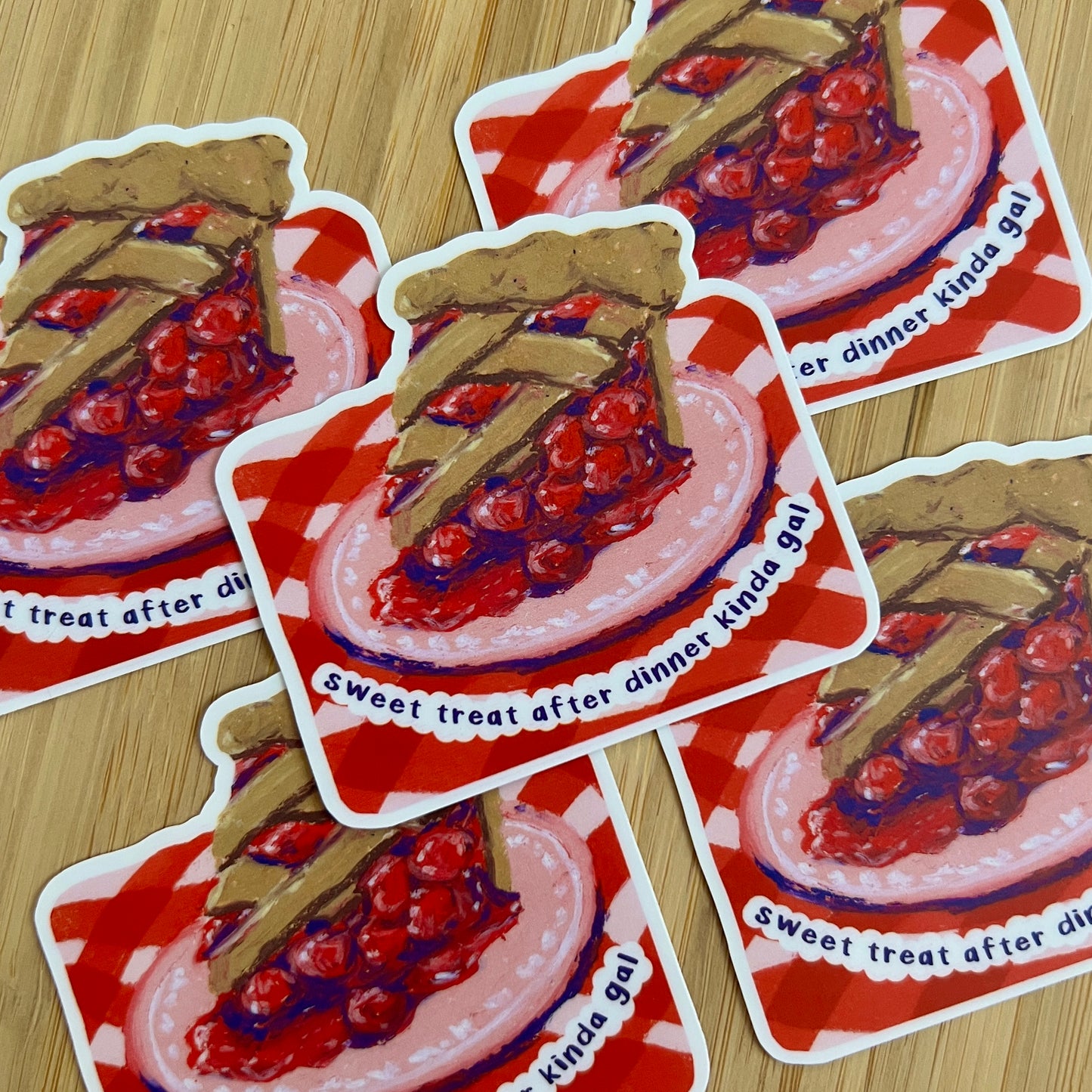 Stickers of cherry pie with text on a wooden surface