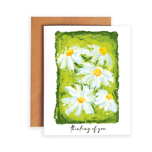 Greeting card with daisy flowers and 'thinking of you' text on a green background