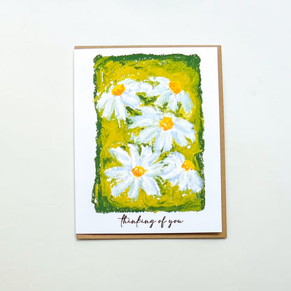 greeting card with illustration of daisies and text 'thinking of you'