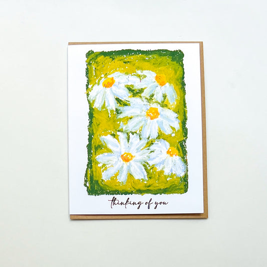 greeting card with illustration of daisies and text 'thinking of you'