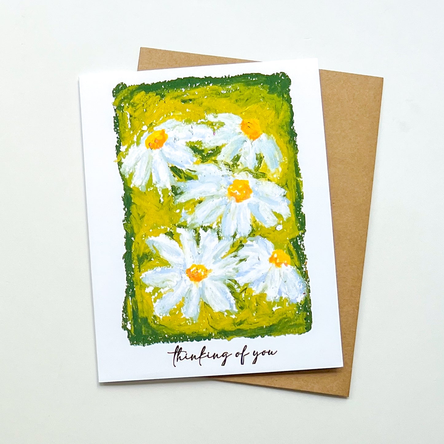 greeting card with illustration of daisies and text 'thinking of you'