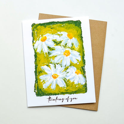 greeting card with illustration of daisies and text 'thinking of you'
