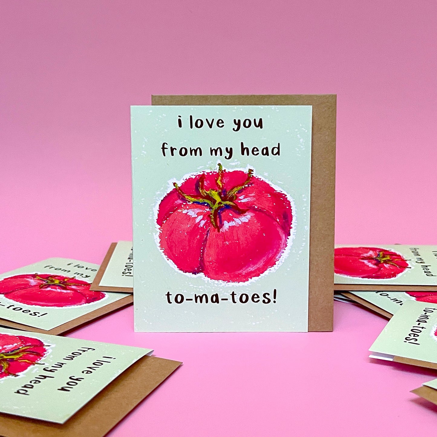 Card with tomato illustration and text 'I love you from my head tomatoes' on a pink background