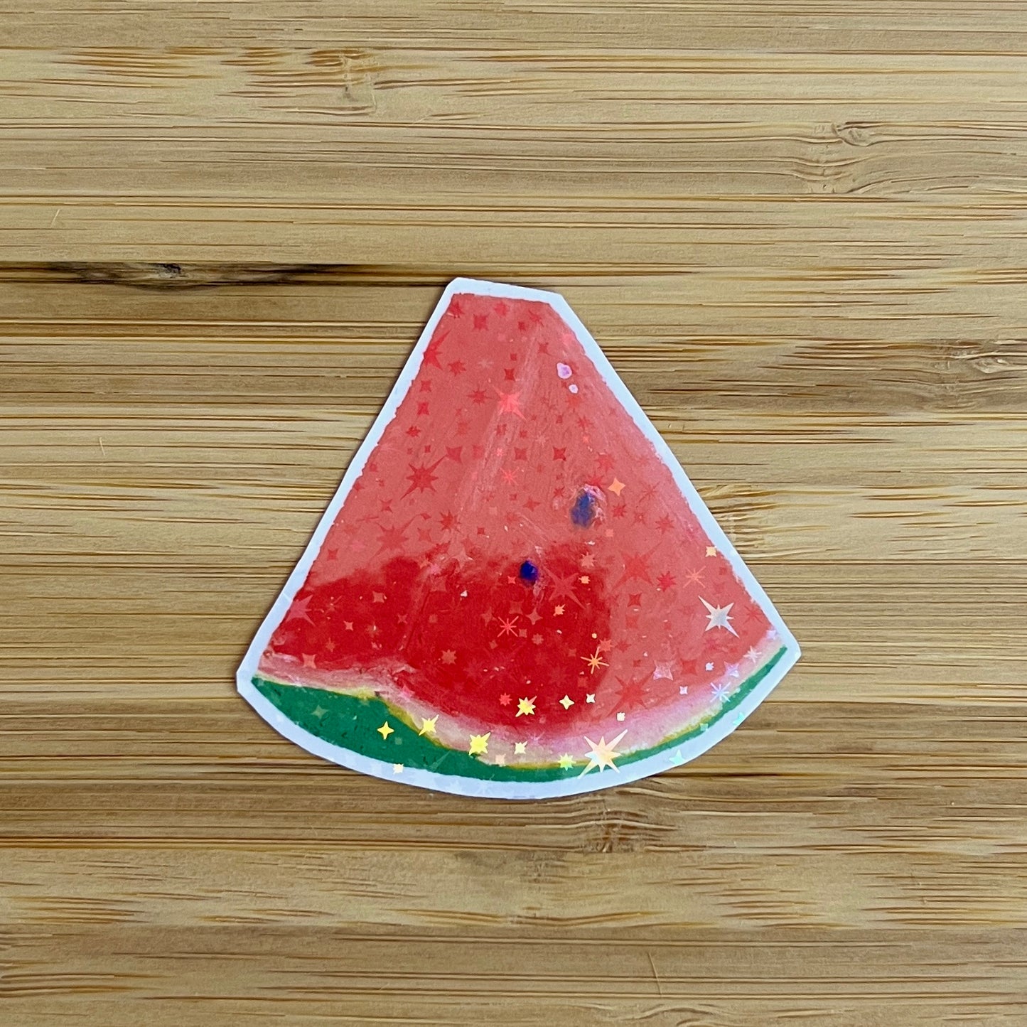 Watermelon slice sticker with star pattern on a wooden surface