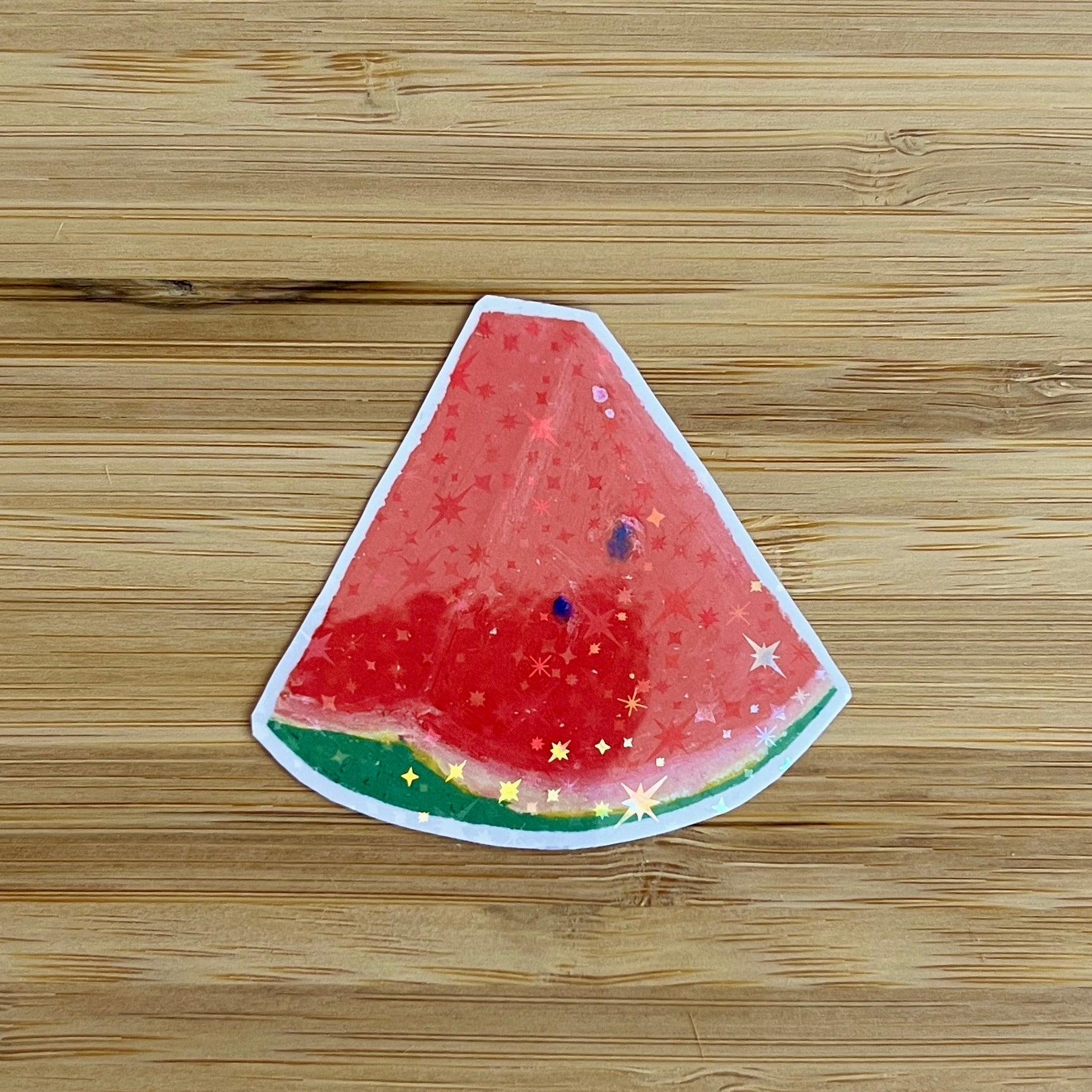 Watermelon slice sticker with star pattern on a wooden surface